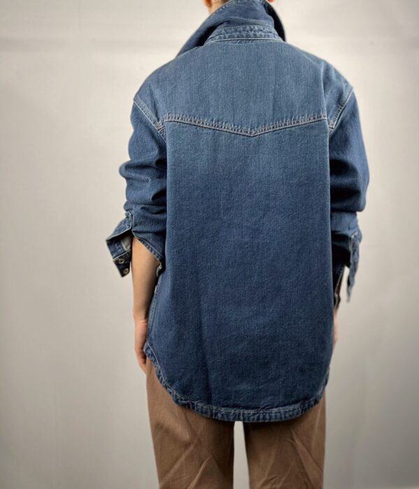 Страничен изглед на дълга дамска дънкова риза със свободен силует Next Level