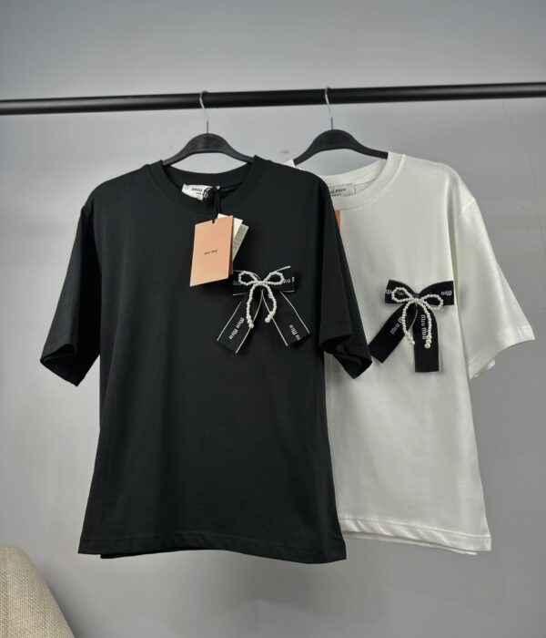 Страничен изглед на черна дамска тениска със стилна сатенена панделка Next Level