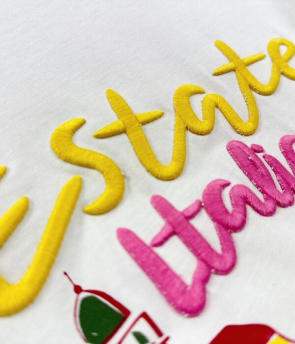 Страничен изглед на бяла дамска тениска с къс ръкав и принт Next Level