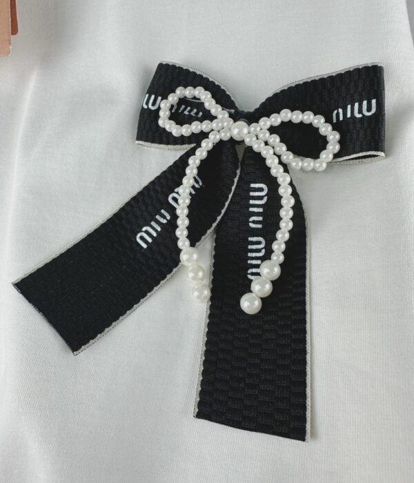 Страничен изглед на бяла дамска тениска с акцент от перли Next Level