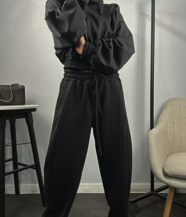 Страничен изглед на черен дамски спортен комплект от две части